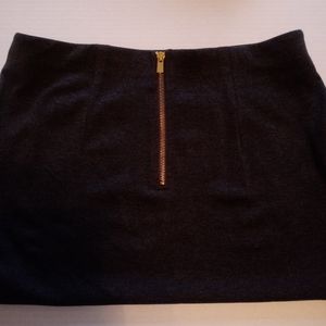 Casual clothing, dark gray skirt.